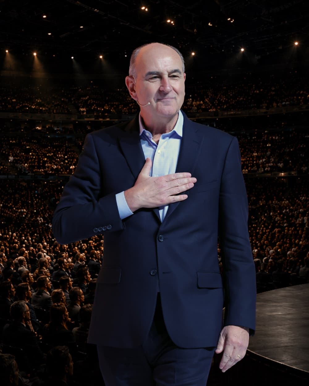 John Mattone on stage before a packed arena, hand on heart